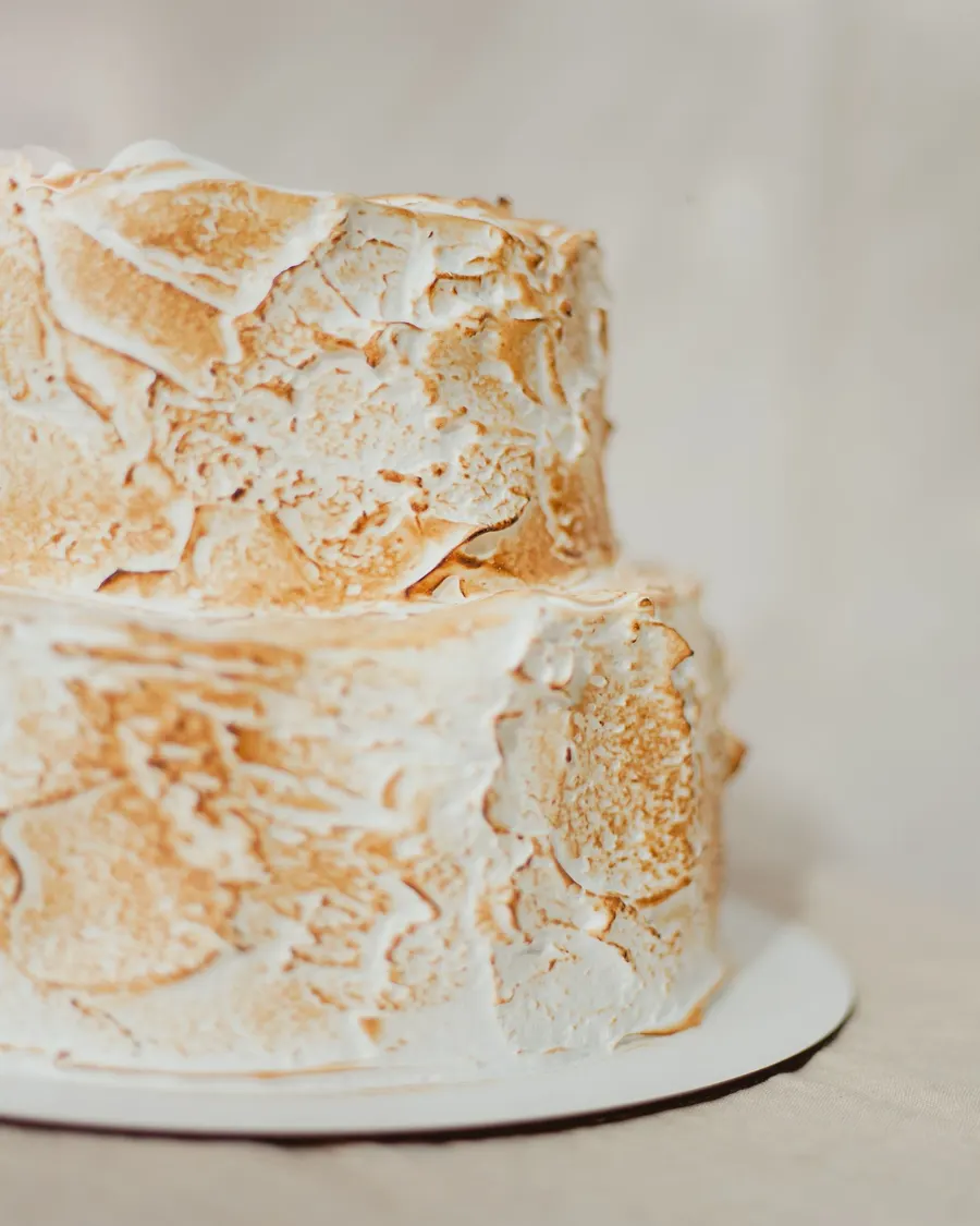 A cake with a meringue topping toasted well past golden, showing dark scorched patches from over-browning