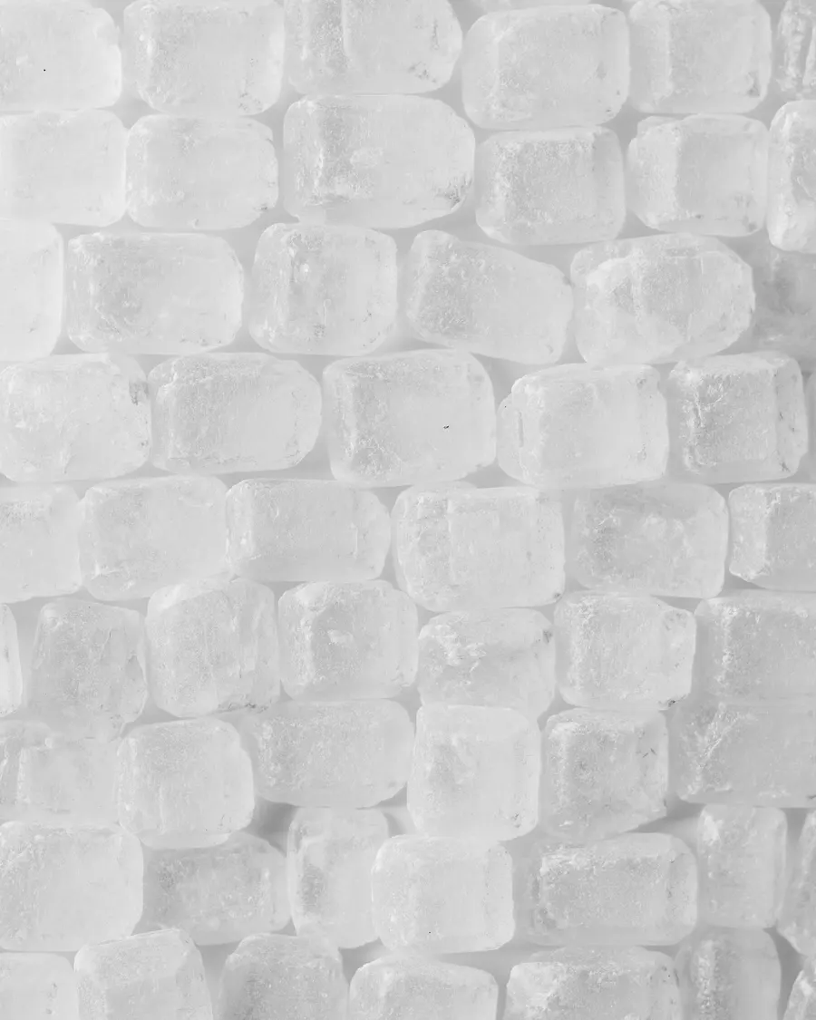 A close-up macro texture of coarse white sugar crystals packed edge to edge